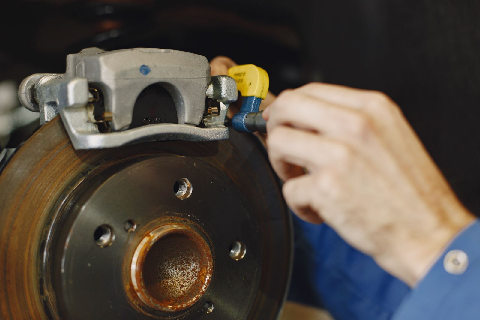 Blue Badge technician performing brake service at a customer's location